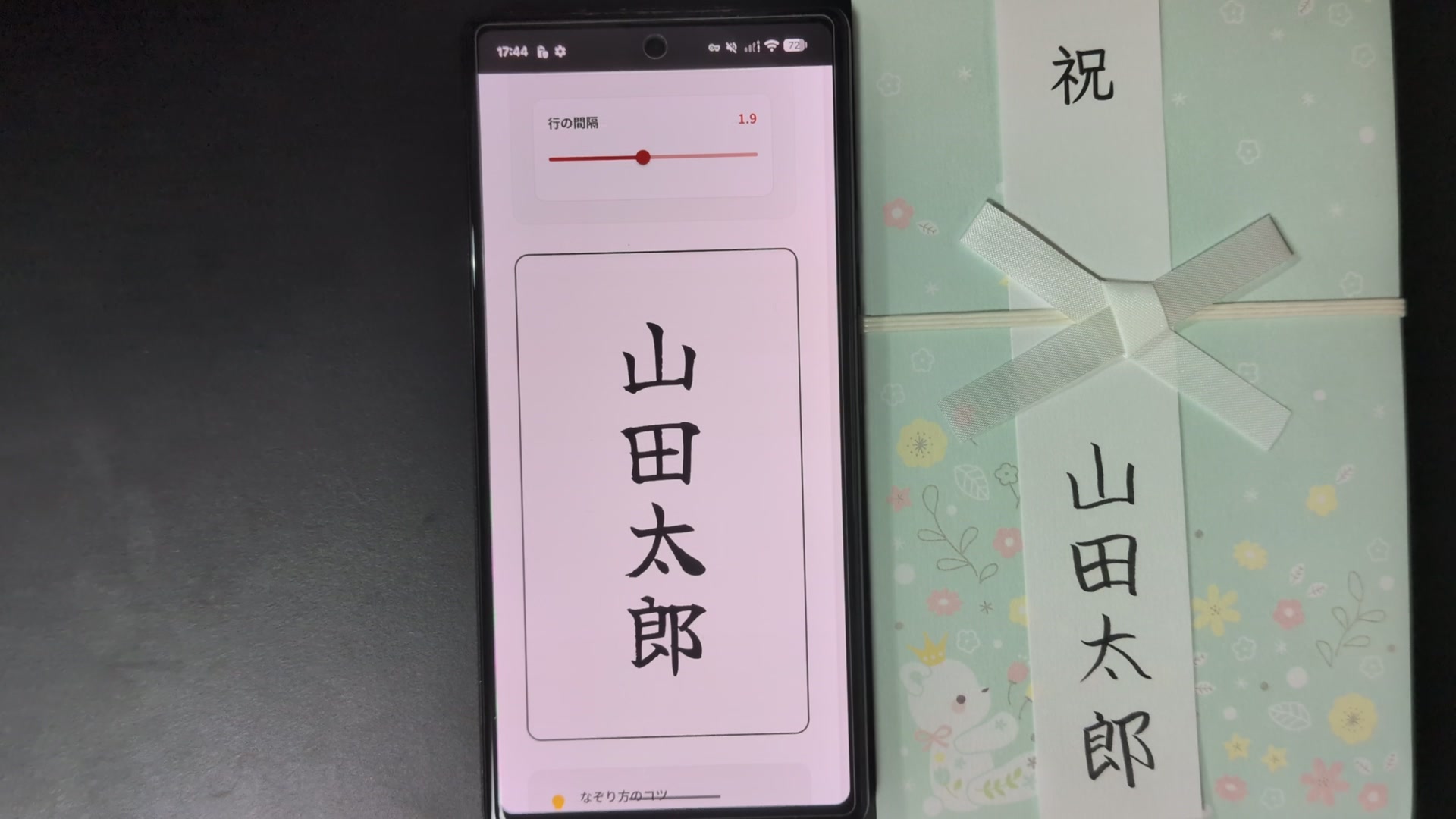 画面に表示したお手本と、なぞり書きを終えた短冊を差したご祝儀袋を並べた実物写真